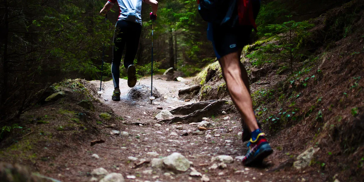 A pair of men's low-cut hiking shoes on a rocky trail with mountains in the background
